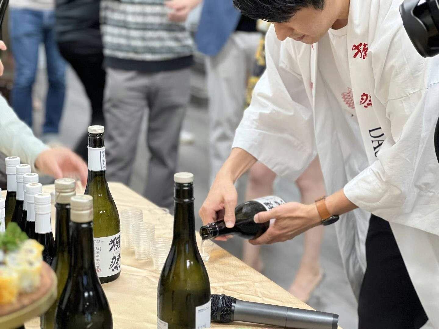 A staff member pours a drink at a brand tasting event.